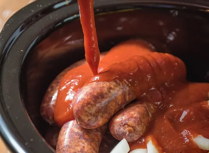 Slow cooker sausage with peppers and onions served on a plate