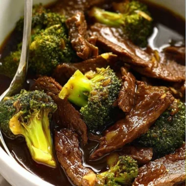 Delicious slow cooker beef broccoli dish served on a plate with rice.