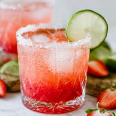 Strawberry Lime Mocktail Margarita in a glass with fresh strawberries and limes