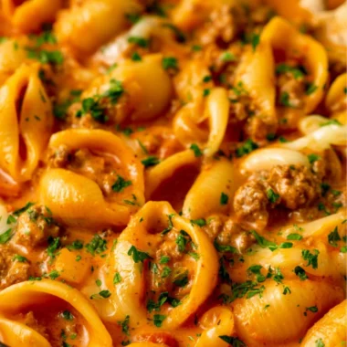 Taco Pasta with ground beef, pasta, cheese, and taco seasoning in a bowl