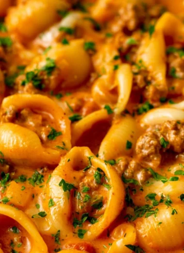 Taco Pasta with ground beef, pasta, cheese, and taco seasoning in a bowl
