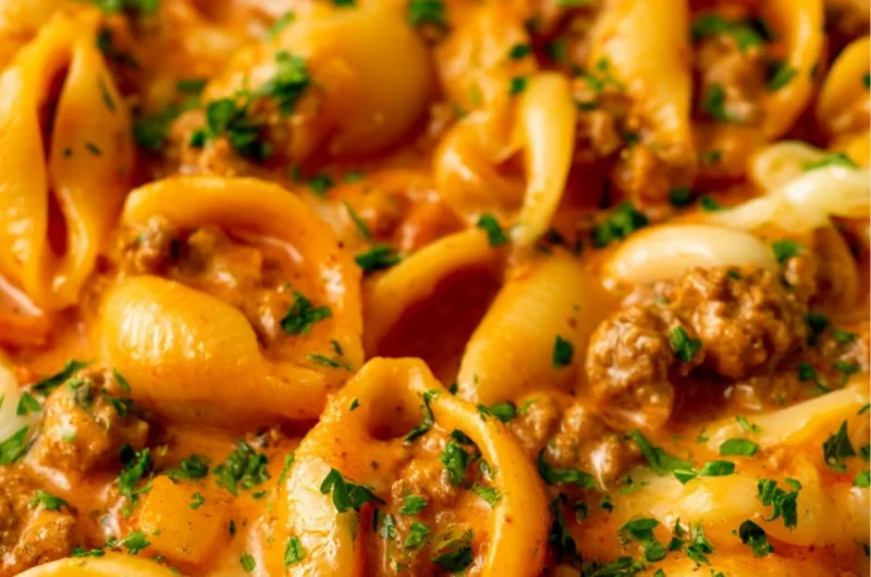 Taco Pasta with ground beef, pasta, cheese, and taco seasoning in a bowl