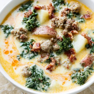 A steaming bowl of Instant Pot Tuscan soup with fresh ingredients and herbs.