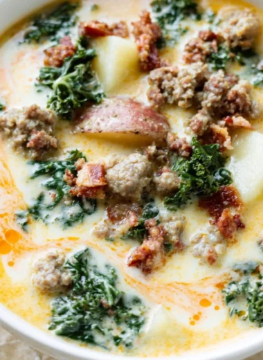 A steaming bowl of Instant Pot Tuscan soup with fresh ingredients and herbs.