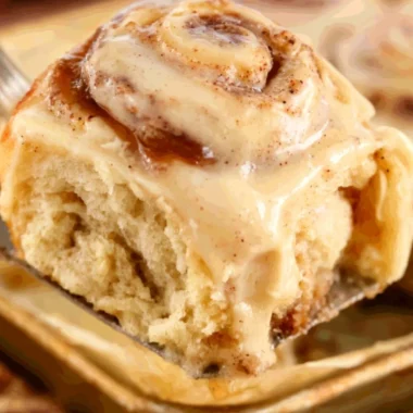 Freshly baked apple butter cinnamon rolls topped with icing and apples