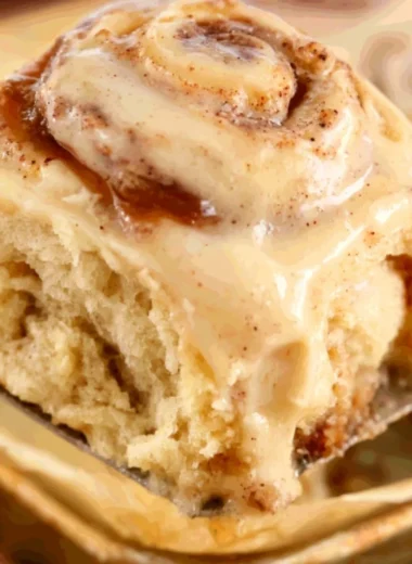 Freshly baked apple butter cinnamon rolls topped with icing and apples
