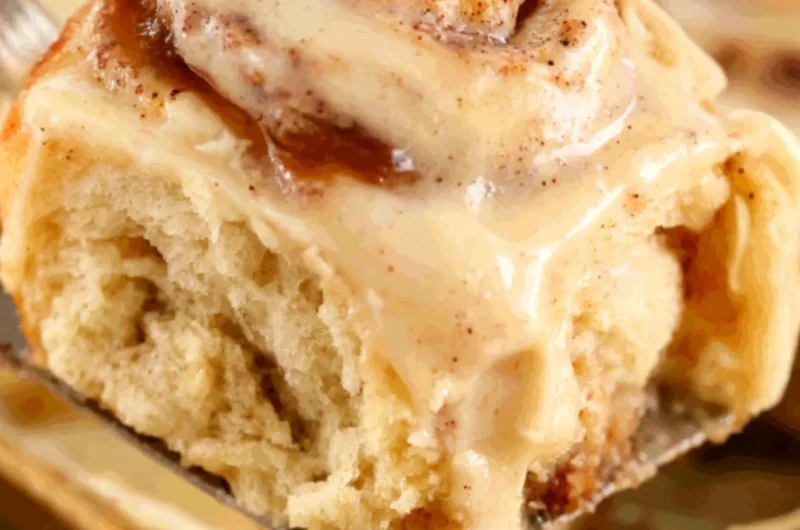 Freshly baked apple butter cinnamon rolls topped with icing and apples