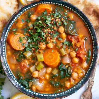 Bowl of cozy Mediterranean soup with fresh vegetables and herbs
