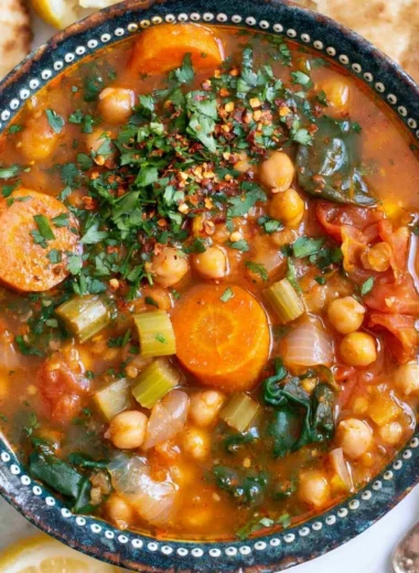 Bowl of cozy Mediterranean soup with fresh vegetables and herbs