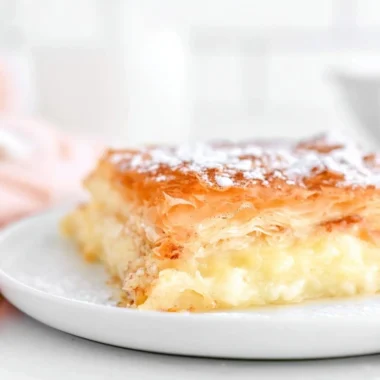 Freshly baked Greek Bougatsa custard pastry served on a plate.