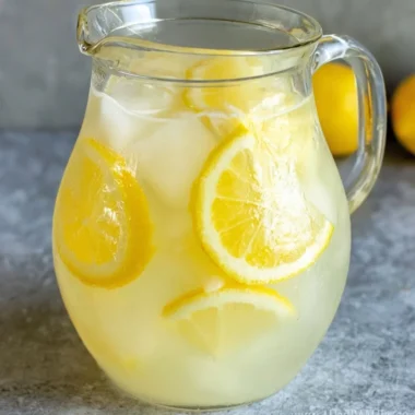 Glass of homemade lemonade with a lemon slice and mint leaves