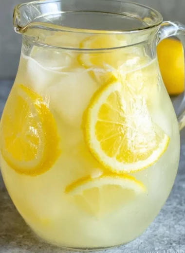 Glass of homemade lemonade with a lemon slice and mint leaves