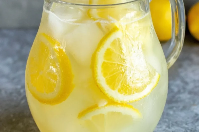 Glass of homemade lemonade with a lemon slice and mint leaves