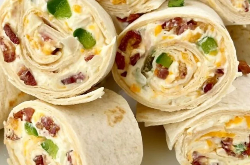 Jalapeno poppers pinwheels on a serving platter with toppings