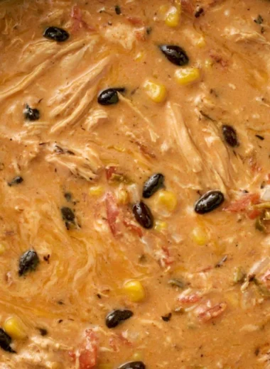 Bowl of slow cooker creamy chicken tortilla soup with toppings.