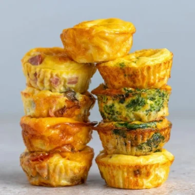 Cozy healthy breakfast egg muffins baked in a muffin tin with vegetables and cheese.