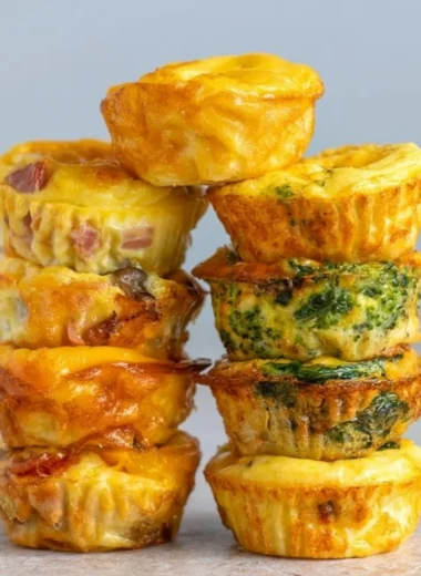 Cozy healthy breakfast egg muffins baked in a muffin tin with vegetables and cheese.
