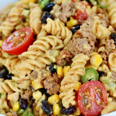 Cozy taco pasta salad garnished with fresh cilantro and diced tomatoes