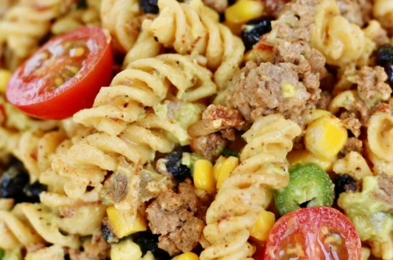 Cozy taco pasta salad garnished with fresh cilantro and diced tomatoes