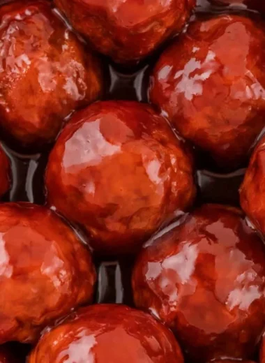 Crockpot Meatballs cooked in grape jelly and BBQ sauce served in a bowl.