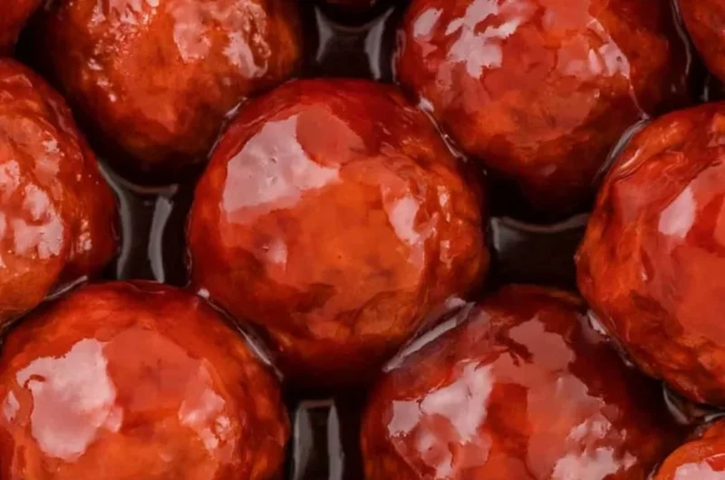 Crockpot Meatballs cooked in grape jelly and BBQ sauce served in a bowl.